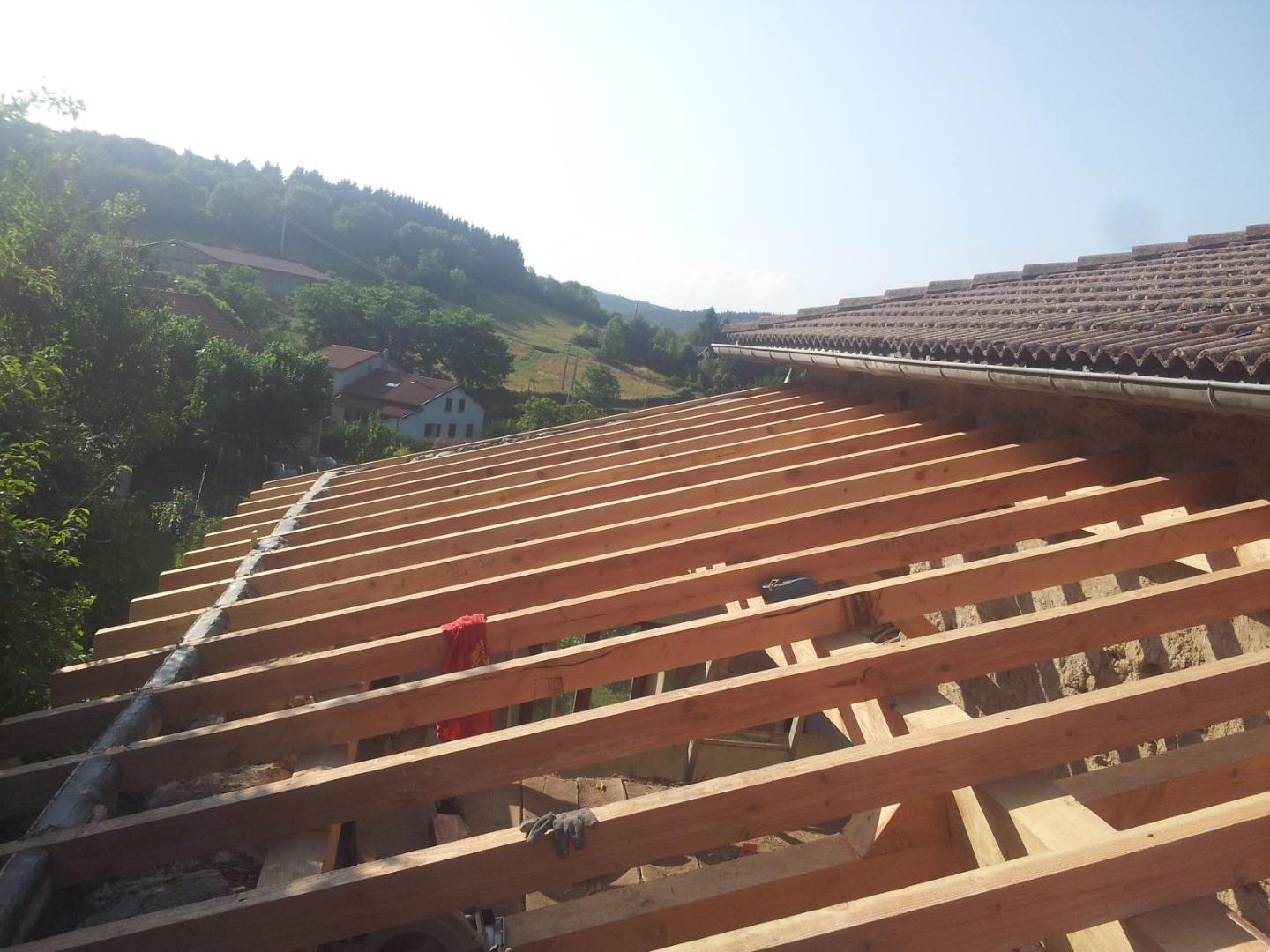 Chevrons neufs d’une toiture prolongeant une couverture en tuiles existante
