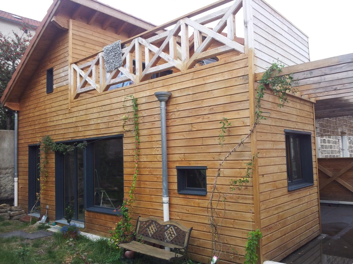 Extension en bois à bardage horizontal avec garde-corps en croix sur le toit-terrasse