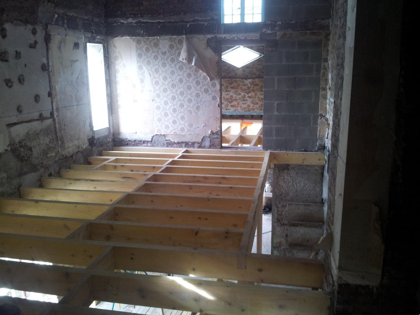 Solivage neuf posé dans une pièce en rénovation aux murs anciens